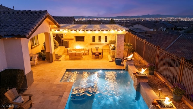 rear view of house with a patio, a fenced backyard, an outdoor living space with a fire pit, a fenced in pool, and a tiled roof