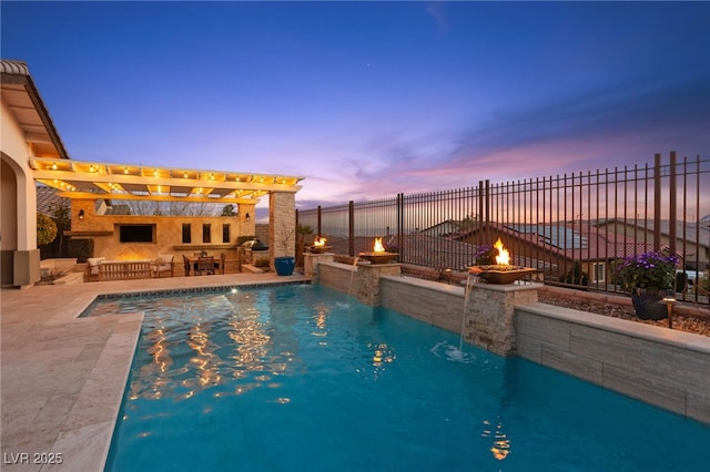 pool at dusk with outdoor dry bar, a pergola, fence, a fire pit, and an outdoor kitchen