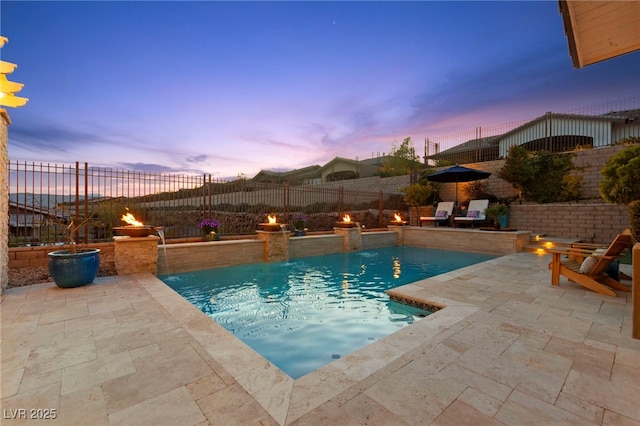 pool at dusk with a fenced in pool, a fenced backyard, and a patio area