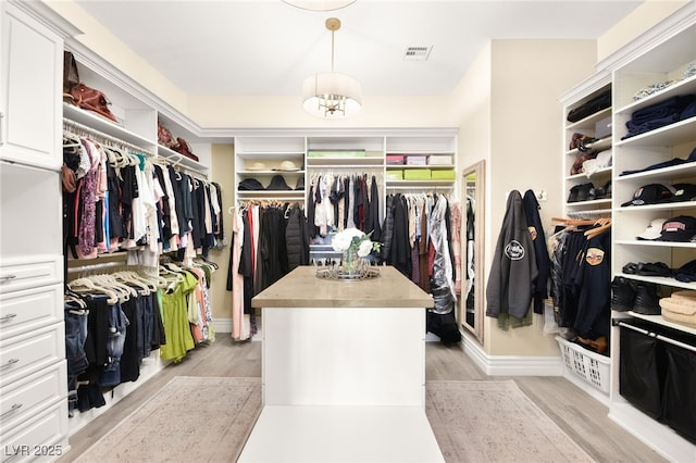 spacious closet with light wood-type flooring and visible vents