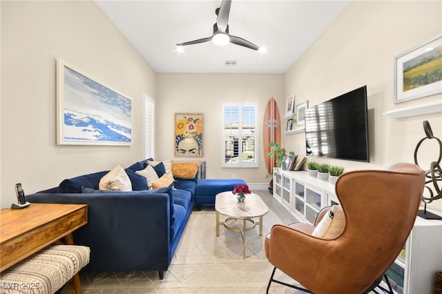 living room featuring visible vents, baseboards, and ceiling fan