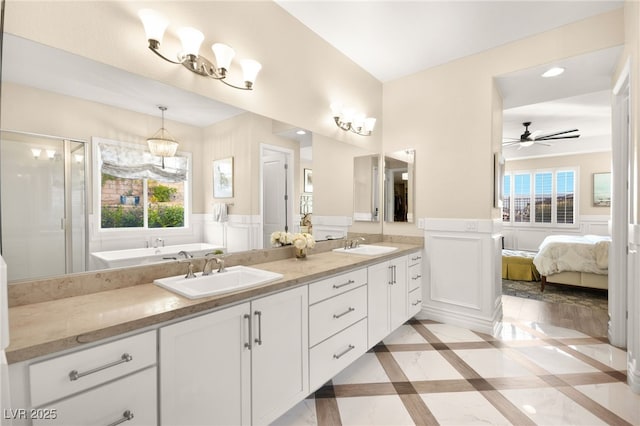 ensuite bathroom featuring a sink, ensuite bathroom, a shower stall, and double vanity