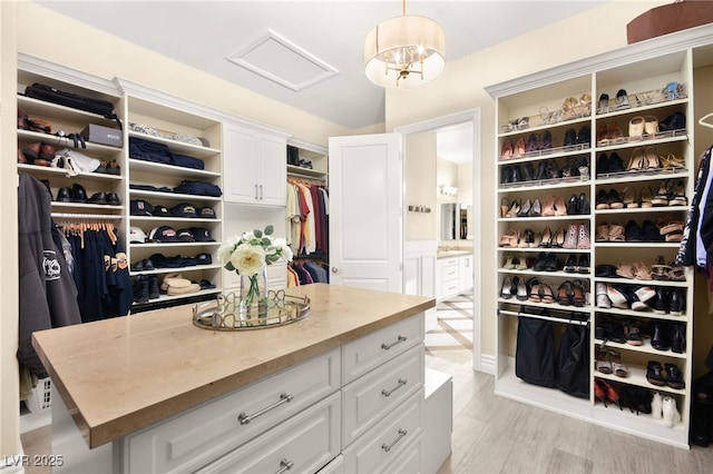 walk in closet featuring attic access and light wood-type flooring