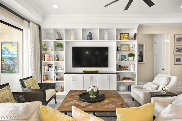 living area featuring built in shelves, wood finished floors, and crown molding