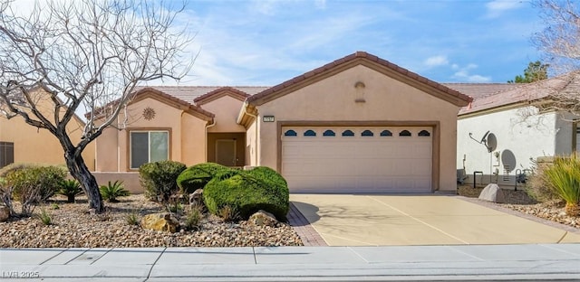 view of front of home with a garage, driveway, a tiled roof, and stucco siding