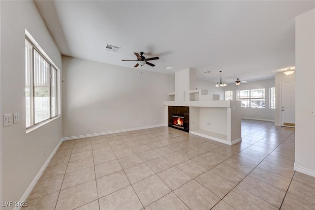 unfurnished living room featuring light tile patterned floors, visible vents, a tiled fireplace, a ceiling fan, and baseboards