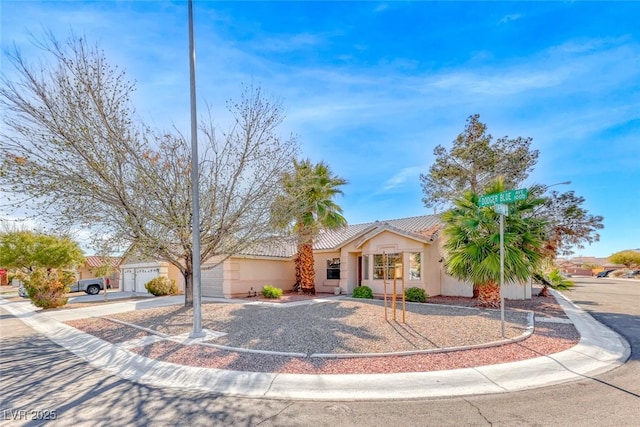 view of front of home with driveway, a tile roof, and stucco siding