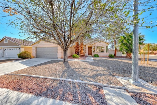 view of front of house featuring driveway, a garage, and stucco siding