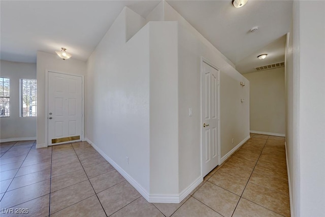 entrance foyer featuring lofted ceiling, visible vents, baseboards, and light tile patterned flooring