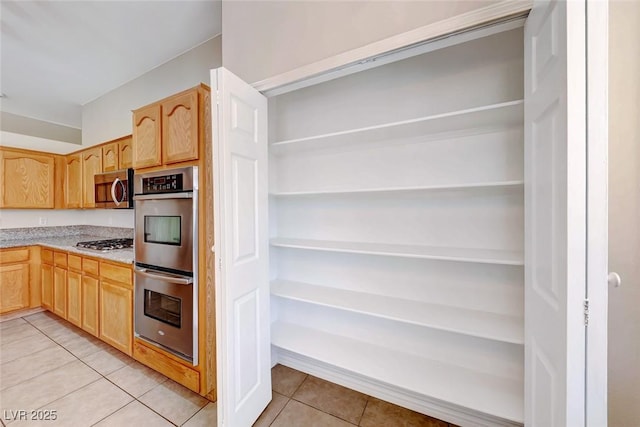 kitchen featuring light countertops, appliances with stainless steel finishes, light tile patterned flooring, and light brown cabinets