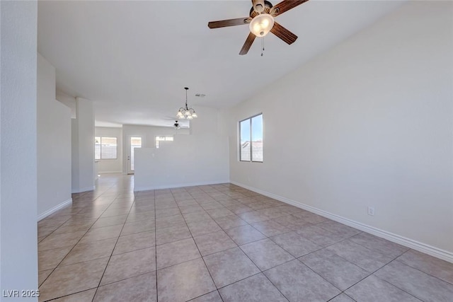 empty room with light tile patterned floors, baseboards, and ceiling fan with notable chandelier