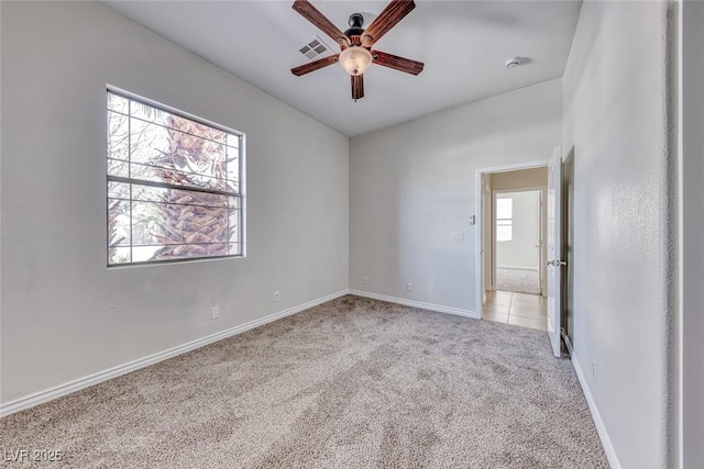 unfurnished room with light colored carpet, ceiling fan, and baseboards