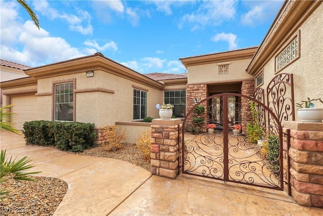 view of exterior entry featuring stone siding, stucco siding, and a gate