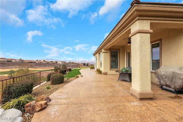 view of patio with a fenced backyard, a grill, and a ceiling fan