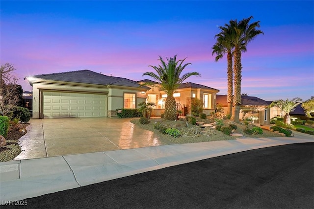 view of front of property featuring stucco siding, an attached garage, and concrete driveway