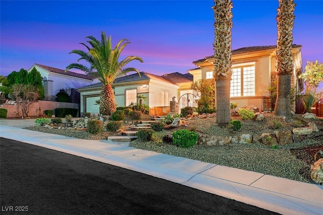 mediterranean / spanish home with stucco siding, concrete driveway, a garage, and fence