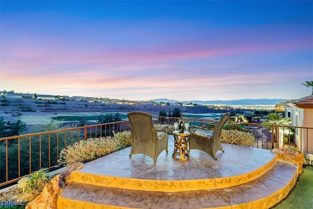 patio terrace at dusk featuring outdoor dining space and a mountain view