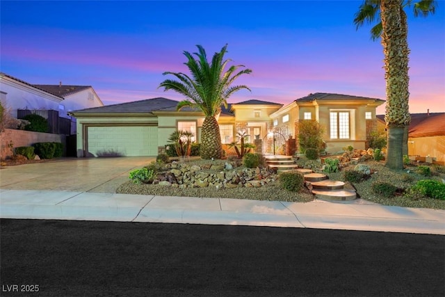 view of front of home with stucco siding, an attached garage, and concrete driveway