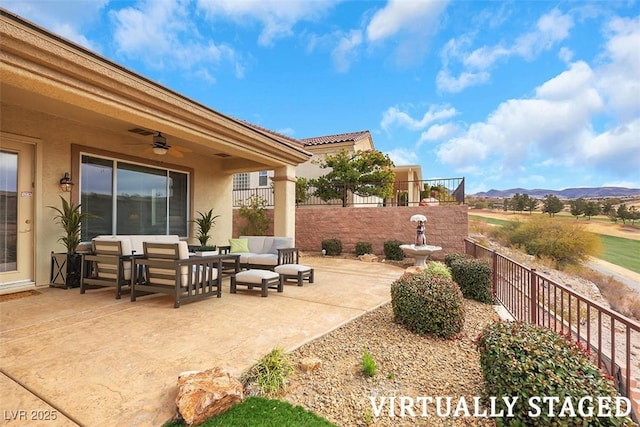 view of patio / terrace with an outdoor hangout area, fence, a mountain view, and ceiling fan