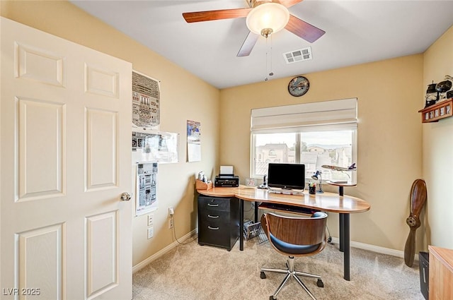 office space featuring light colored carpet, baseboards, a ceiling fan, and visible vents