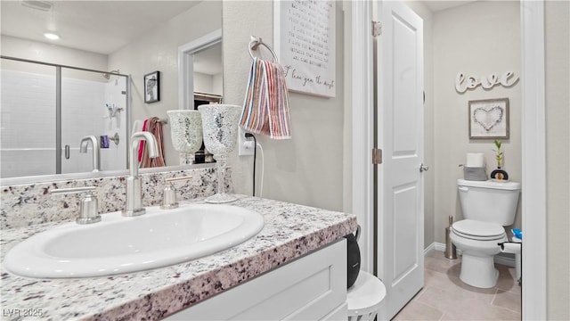 bathroom with a stall shower, tile patterned flooring, vanity, and toilet