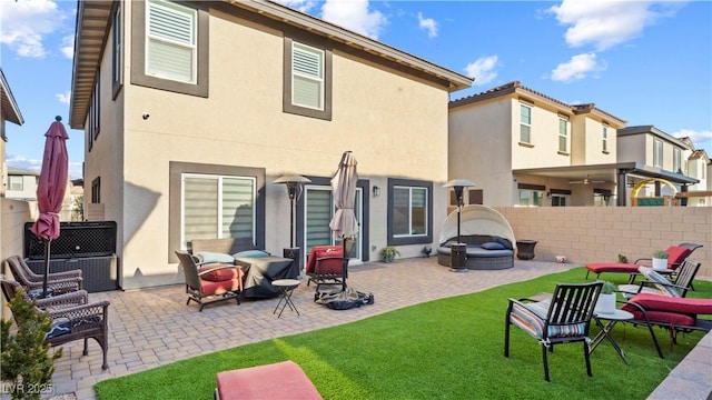 back of house featuring a fire pit, fence, a patio, and stucco siding