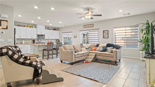 living room with ceiling fan, light tile patterned flooring, a wealth of natural light, and recessed lighting