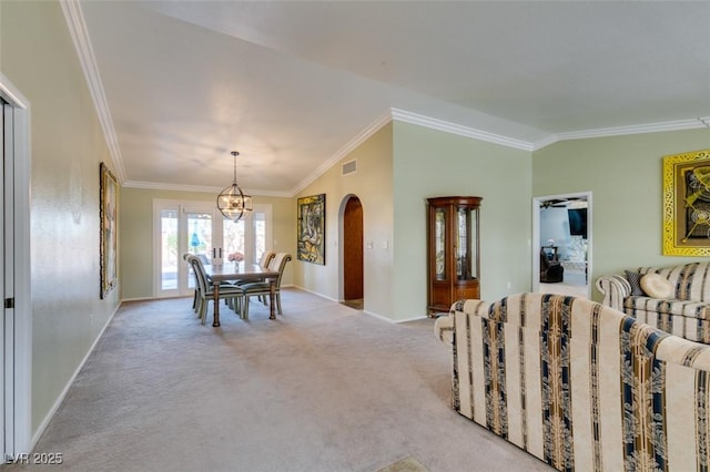 dining area with arched walkways, light carpet, visible vents, ornamental molding, and an inviting chandelier