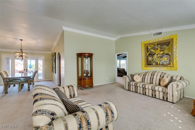 living room with a notable chandelier, visible vents, baseboards, ornamental molding, and carpet