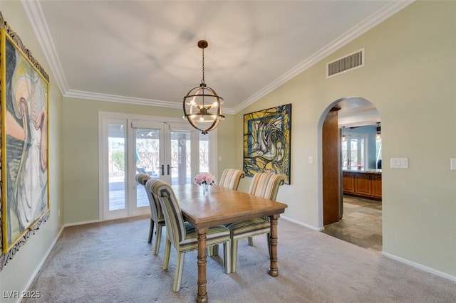 dining room with ornamental molding, carpet, visible vents, and arched walkways