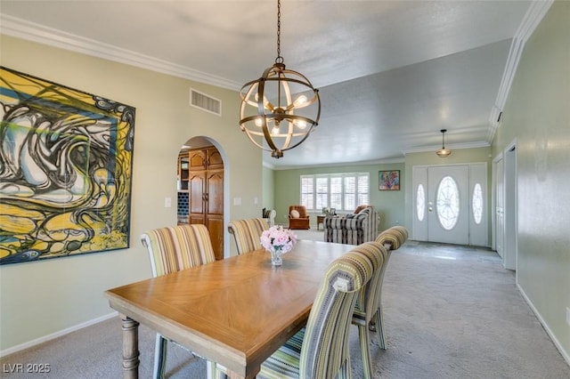 dining area featuring arched walkways, carpet, visible vents, and crown molding