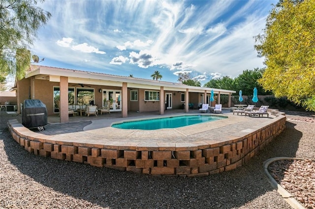 outdoor pool featuring a ceiling fan, french doors, a patio area, and grilling area