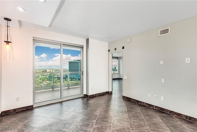 empty room with dark tile patterned flooring, recessed lighting, visible vents, and baseboards