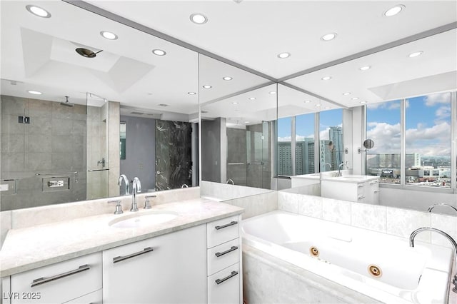 full bath with a city view, recessed lighting, a stall shower, vanity, and a jetted tub