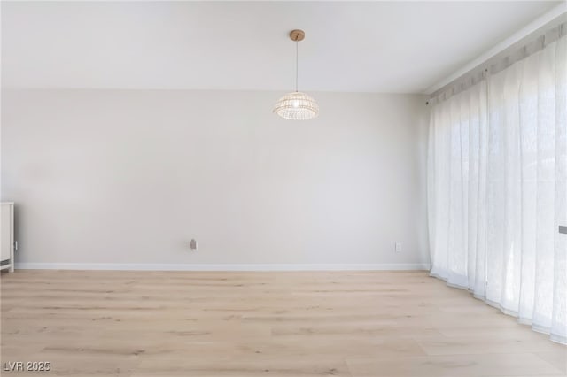 empty room with light wood finished floors and baseboards