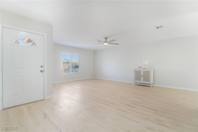 foyer with light wood-style flooring, a ceiling fan, visible vents, and baseboards