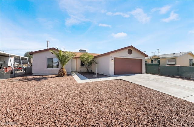 ranch-style home with driveway, an attached garage, fence, and stucco siding