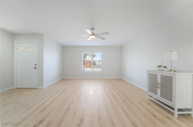 unfurnished living room featuring a ceiling fan, light wood-style flooring, and baseboards