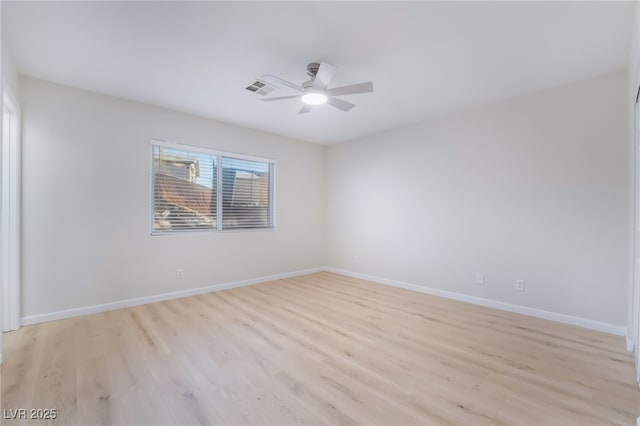 empty room featuring light wood-type flooring, visible vents, ceiling fan, and baseboards