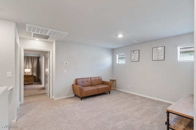 sitting room with light carpet, visible vents, and a wealth of natural light