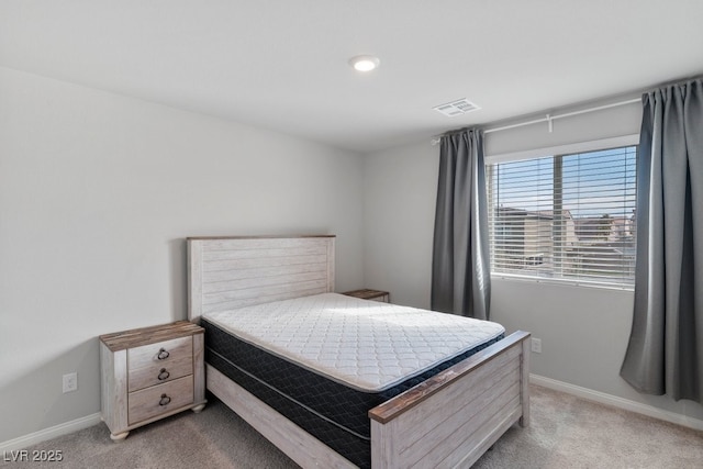 bedroom with visible vents, light carpet, and baseboards