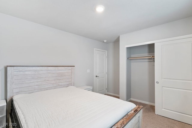 bedroom featuring baseboards, a closet, and light colored carpet