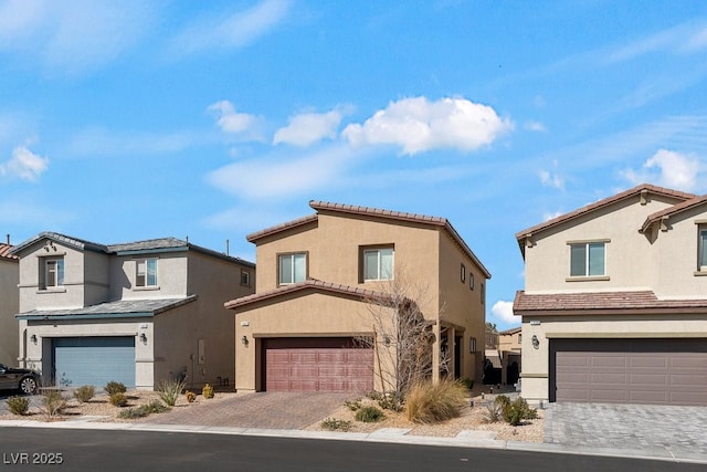 view of front of home with decorative driveway, an attached garage, a residential view, and stucco siding