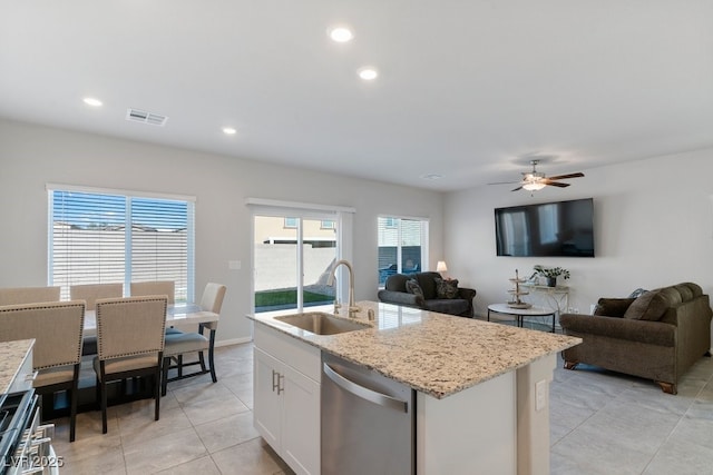 kitchen with open floor plan, white cabinets, a sink, and stainless steel dishwasher