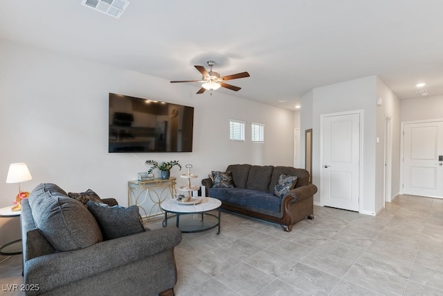 living room featuring ceiling fan, visible vents, and baseboards