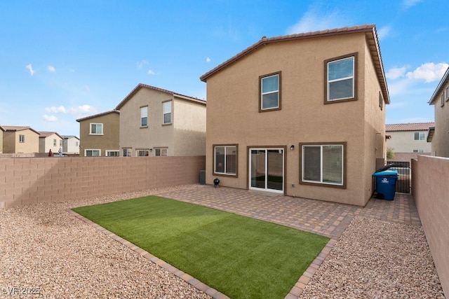 rear view of property featuring a residential view, a fenced backyard, a patio, and stucco siding