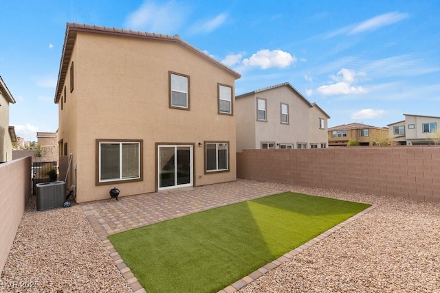 rear view of property with a patio, central AC unit, a fenced backyard, a residential view, and stucco siding