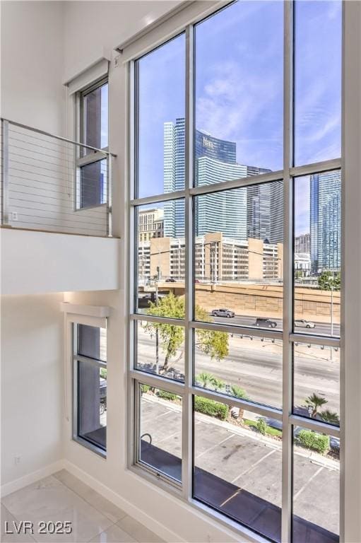 doorway to outside with a healthy amount of sunlight, baseboards, and a city view