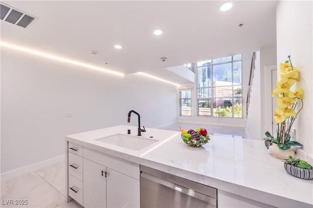 kitchen featuring visible vents, white cabinets, dishwasher, light stone counters, and a sink