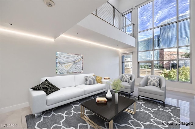 living area featuring baseboards, a view of city, and a high ceiling